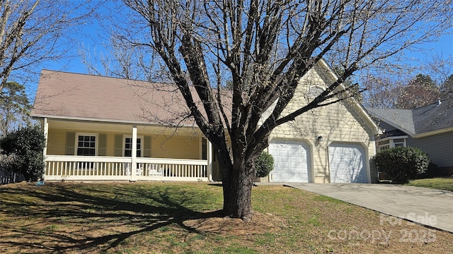 view of front of house featuring covered porch, concrete driveway, a front lawn, and a garage