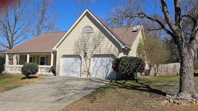 view of front facade featuring a garage, concrete driveway, covered porch, and fence