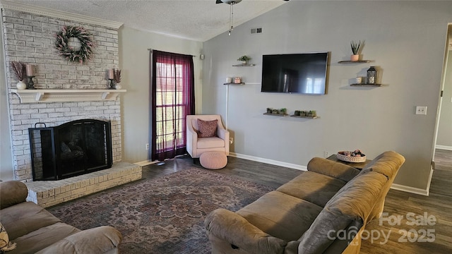 living room featuring a fireplace, lofted ceiling, visible vents, a textured ceiling, and wood finished floors