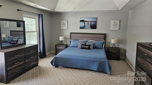 bedroom with lofted ceiling, carpet flooring, a textured ceiling, and baseboards