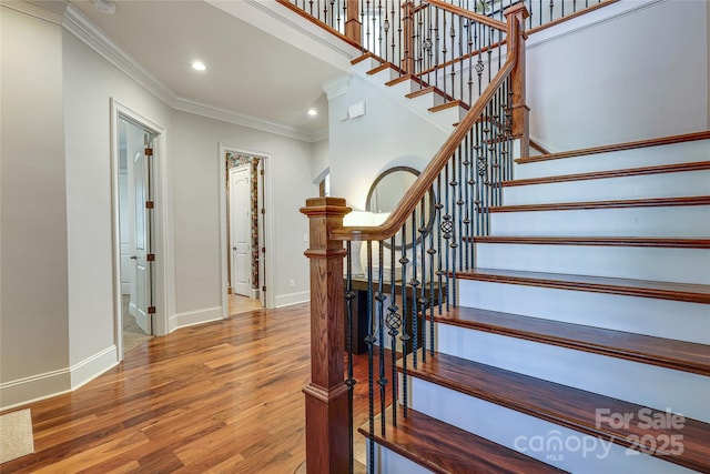 stairway featuring ornamental molding and hardwood / wood-style flooring