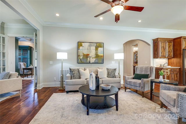 living room featuring ceiling fan, ornamental molding, and dark hardwood / wood-style floors