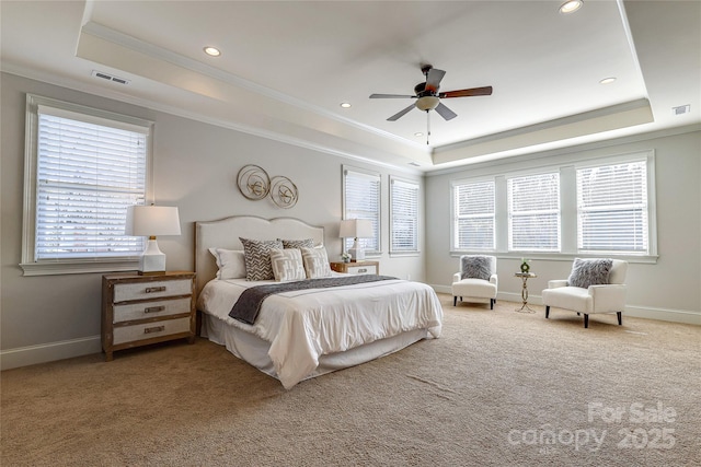 bedroom with a tray ceiling, ceiling fan, carpet flooring, and crown molding