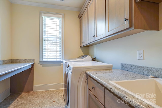 washroom with cabinets, washer and dryer, sink, and crown molding