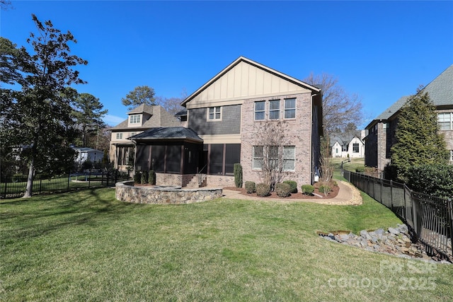 rear view of property featuring a gazebo, a sunroom, and a lawn