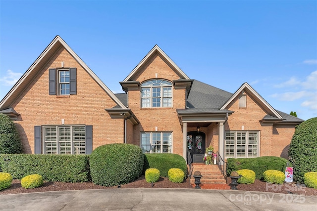 traditional-style home with brick siding and roof with shingles