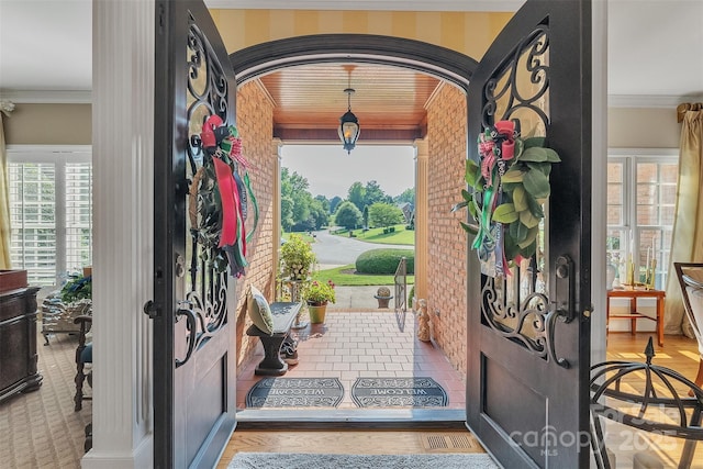 foyer featuring arched walkways and crown molding