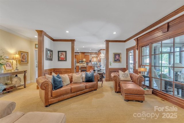 living area with light carpet, a wainscoted wall, ornamental molding, and recessed lighting