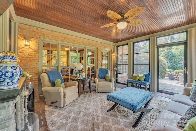 sunroom with a ceiling fan and wooden ceiling