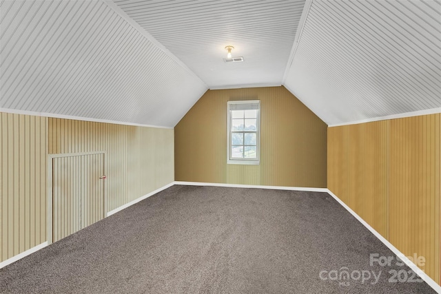 additional living space with carpet floors, visible vents, and vaulted ceiling