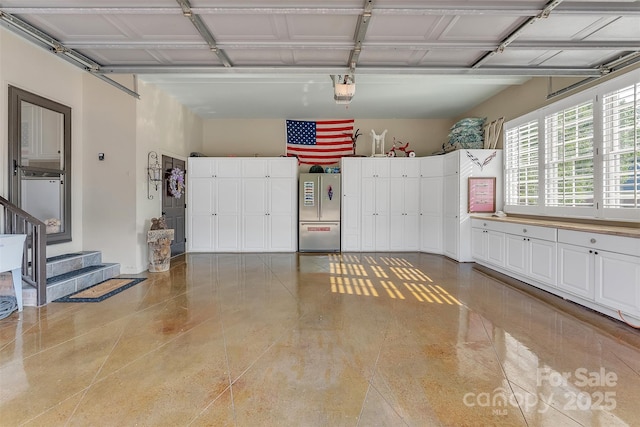 garage featuring a garage door opener and freestanding refrigerator