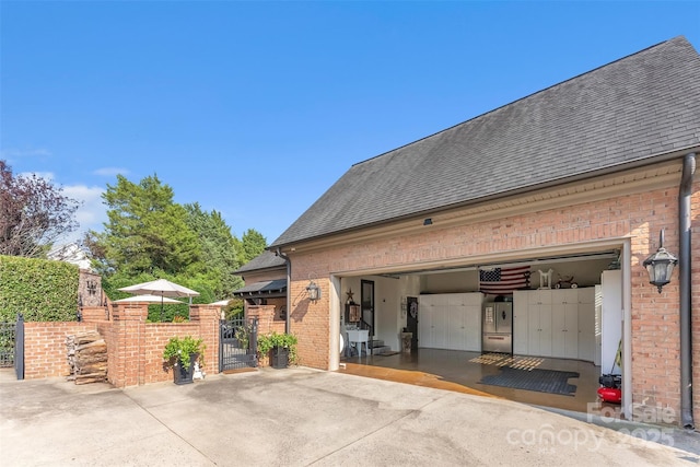 back of property with brick siding and roof with shingles