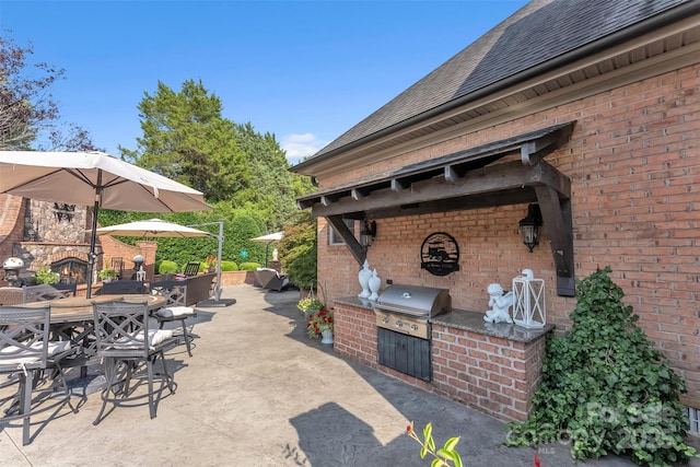 view of patio featuring outdoor dining space, an outdoor kitchen, and a grill