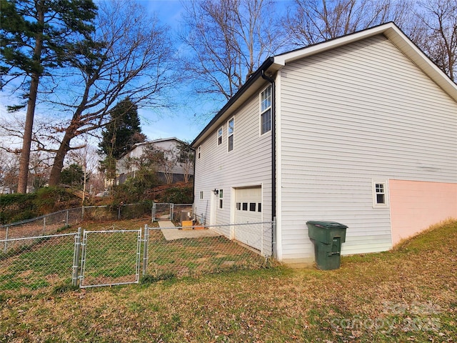 view of home's exterior with a garage, a yard, fence, and a gate