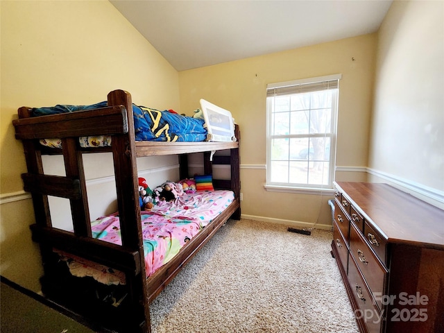 bedroom with lofted ceiling, visible vents, light carpet, and baseboards