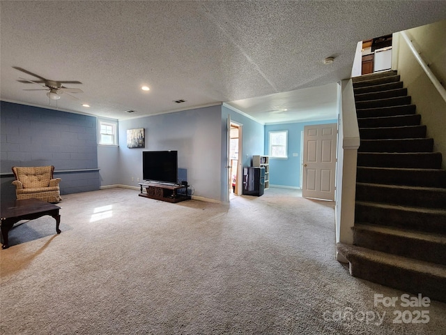 unfurnished living room featuring a healthy amount of sunlight, a textured ceiling, stairway, and carpet flooring