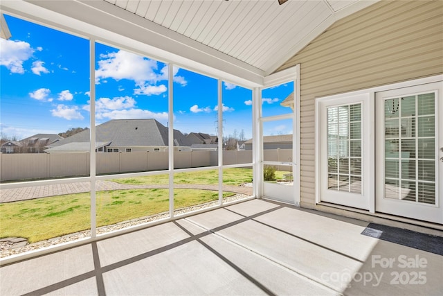 unfurnished sunroom with lofted ceiling and a residential view