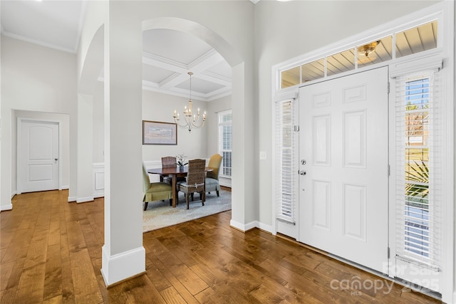 foyer entrance with coffered ceiling, plenty of natural light, and hardwood / wood-style flooring