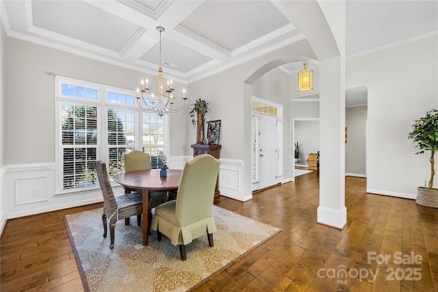 dining space featuring arched walkways, crown molding, a notable chandelier, wood-type flooring, and coffered ceiling