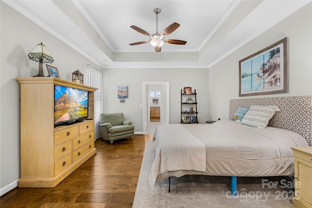 bedroom with dark wood-type flooring, a raised ceiling, crown molding, and baseboards