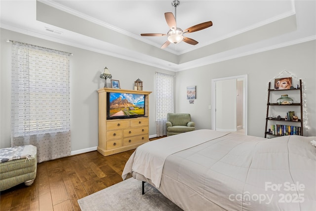 bedroom featuring a raised ceiling, visible vents, crown molding, and hardwood / wood-style floors