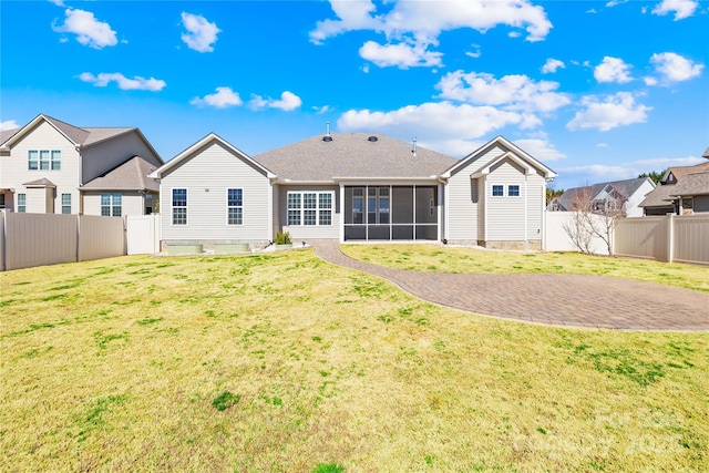 rear view of property with a yard, a fenced backyard, and a sunroom