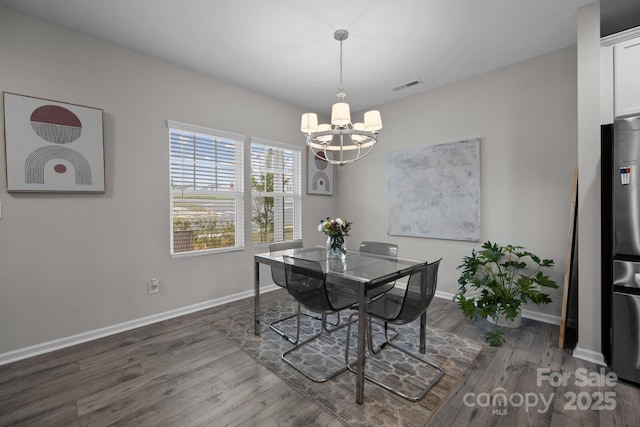 dining area featuring dark hardwood / wood-style floors and an inviting chandelier