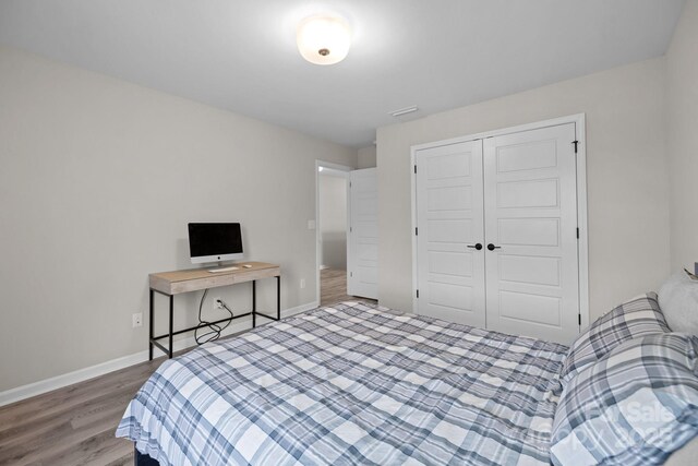 bedroom with a closet and hardwood / wood-style floors