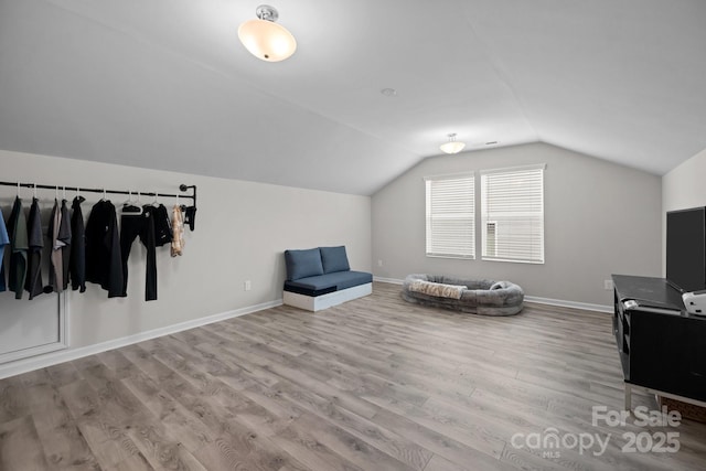 living area featuring light hardwood / wood-style floors and vaulted ceiling