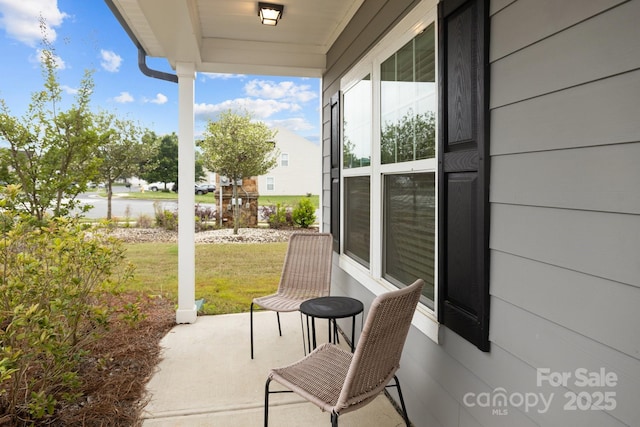 view of patio with a water view and covered porch