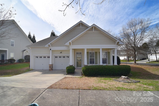 view of front of home with a front lawn, a garage, covered porch, and driveway