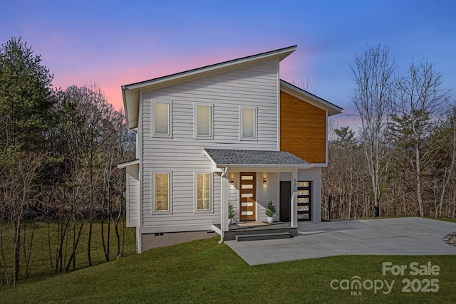 modern home with crawl space, concrete driveway, a yard, and roof with shingles