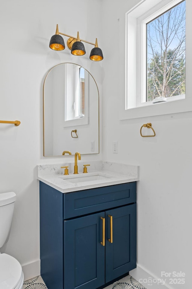 bathroom with vanity, baseboards, and toilet