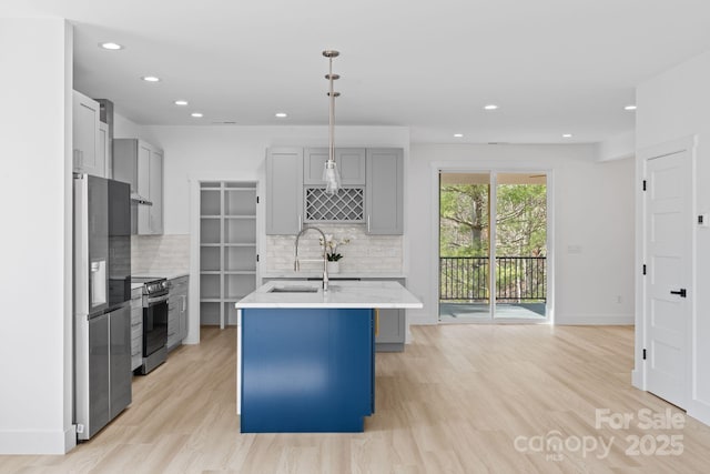 kitchen with recessed lighting, light countertops, appliances with stainless steel finishes, and a sink