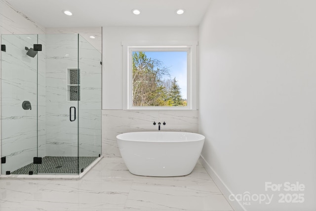 full bath featuring a freestanding tub, baseboards, marble finish floor, a marble finish shower, and recessed lighting