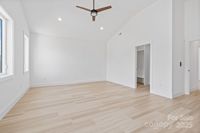 unfurnished room featuring visible vents, light wood-style flooring, ceiling fan, and high vaulted ceiling