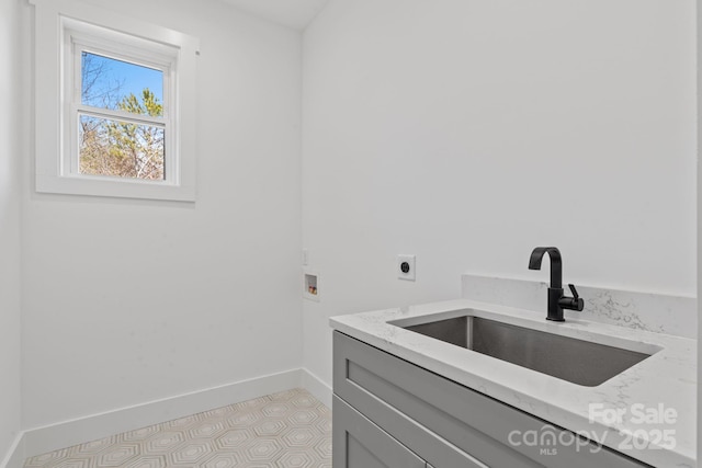 laundry area with a sink, cabinet space, hookup for an electric dryer, washer hookup, and baseboards