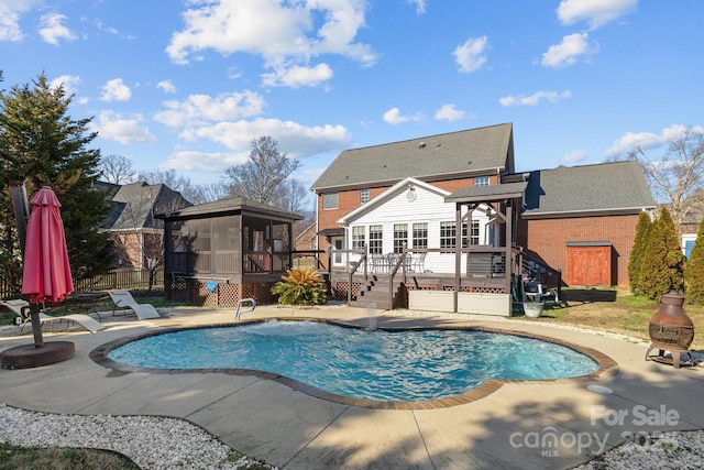 view of swimming pool featuring a fenced in pool, stairway, a sunroom, fence, and a wooden deck