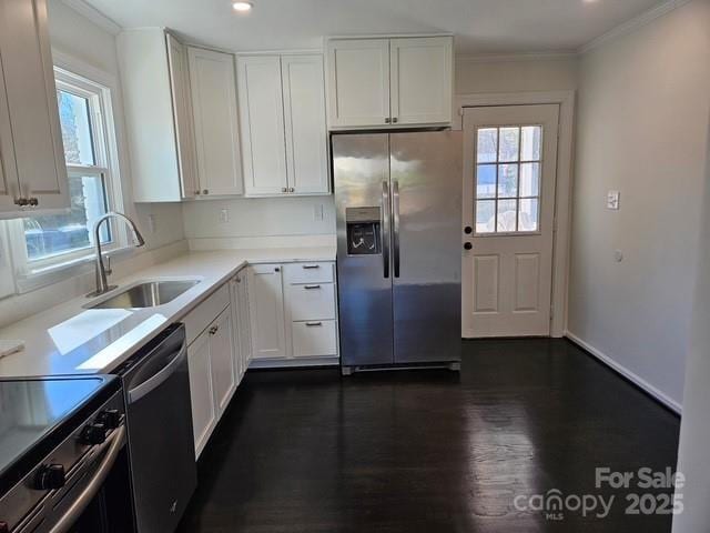 kitchen featuring appliances with stainless steel finishes, sink, crown molding, and white cabinets