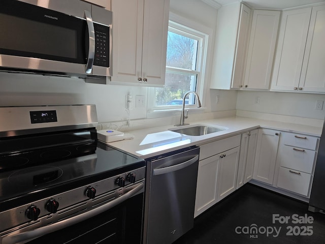 kitchen with appliances with stainless steel finishes, sink, and white cabinets