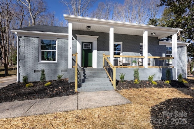 view of front of home featuring crawl space, a porch, and brick siding