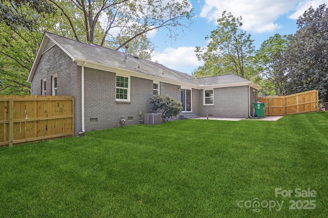rear view of property with central AC unit, a yard, crawl space, fence, and brick siding