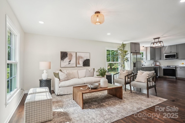 living room with dark wood-style flooring and recessed lighting