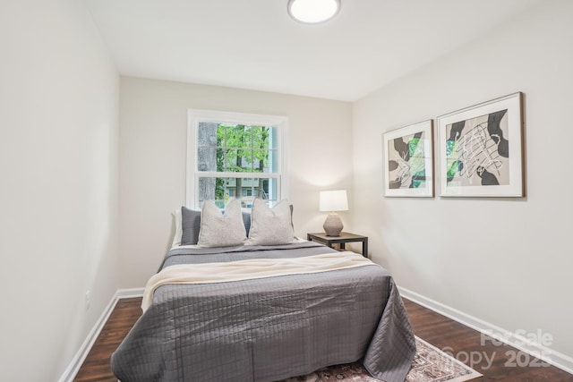 bedroom with wood finished floors and baseboards