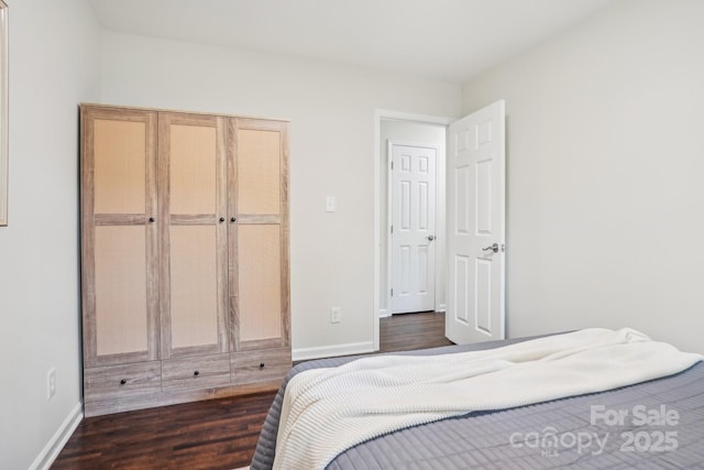 bedroom featuring dark wood-style flooring and baseboards