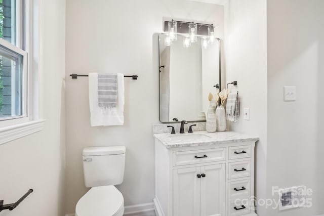 half bath featuring vanity and toilet