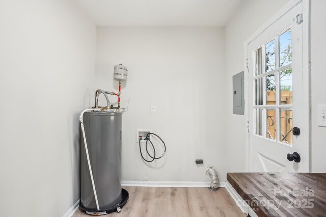 laundry area featuring water heater, electric panel, light wood-style flooring, washer hookup, and laundry area