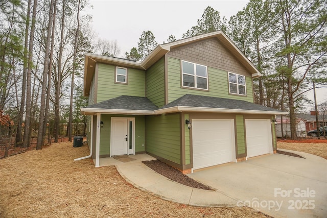 view of front of home with driveway, a shingled roof, and an attached garage