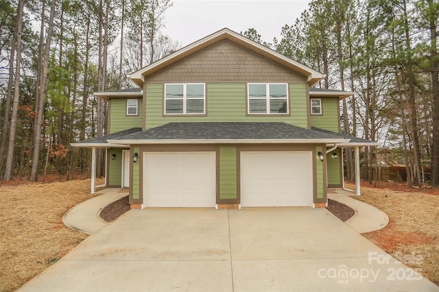 view of front of house with a garage, concrete driveway, and roof with shingles