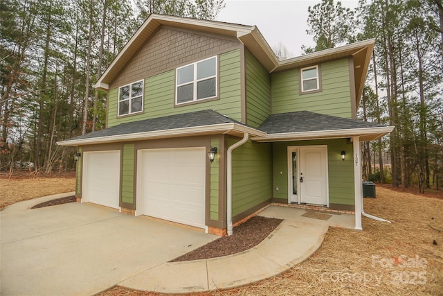 view of front of house with a garage, a shingled roof, and central AC unit